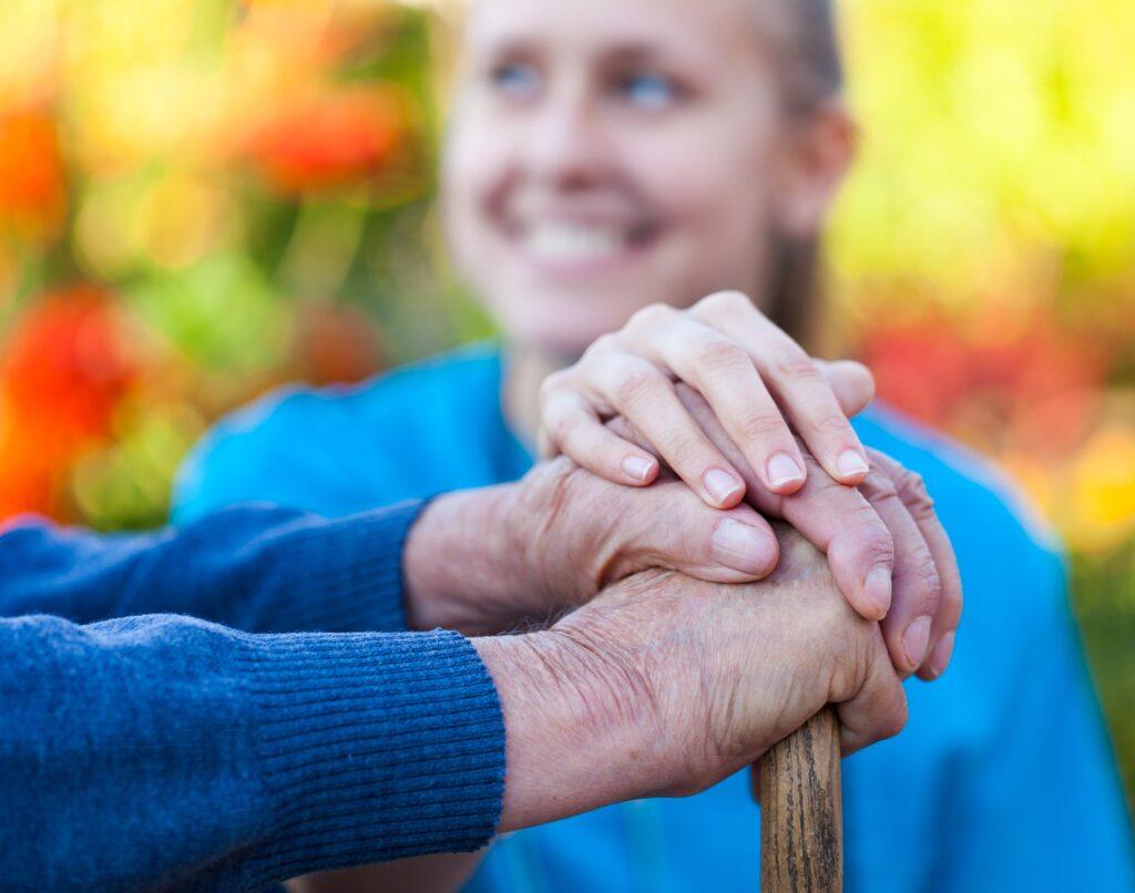 Young female doctor holding his patient hand.